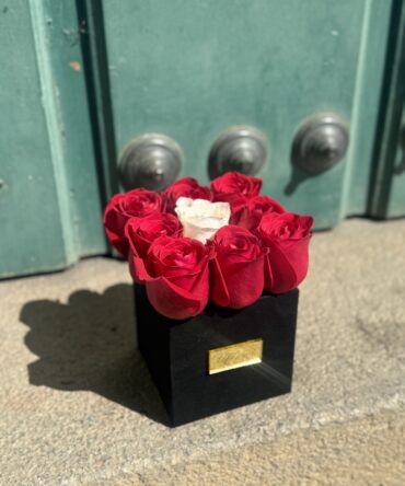 Box nueve rosas con rosa blanca en centro
