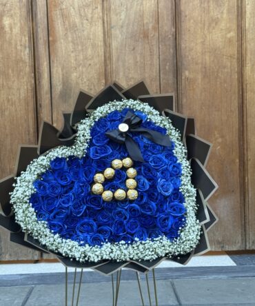 Corazón de ochenta rosas azules con ferreros